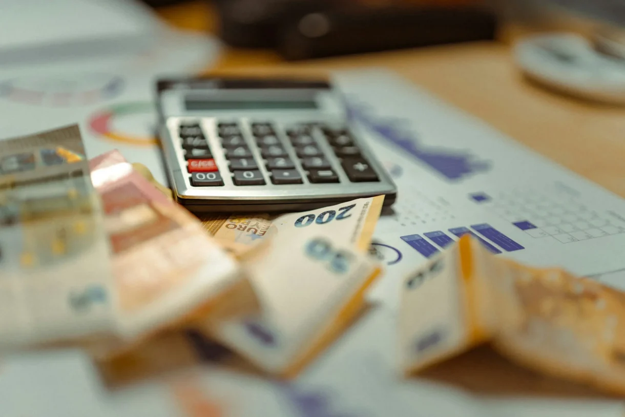 Rekenmachine met losgeld en papieren met analyses eromheen.